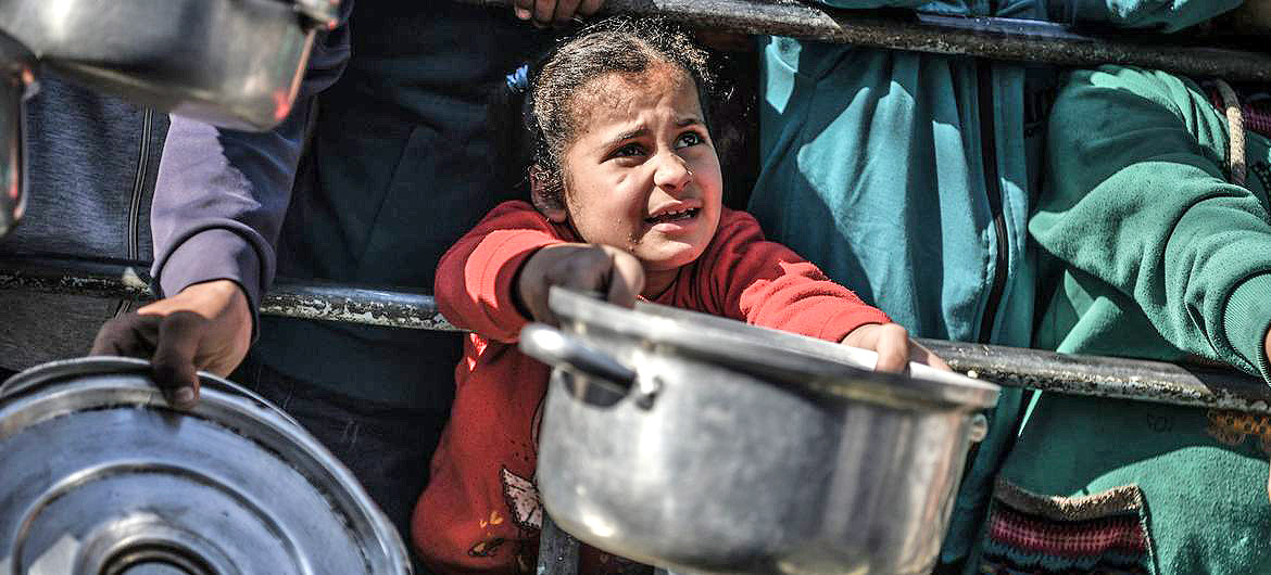 © UNICEF/Abed Zagout Una niña de 8 años espera su turno para recibir alimentos en Rafah, en el sur de la Franja de Gaza.